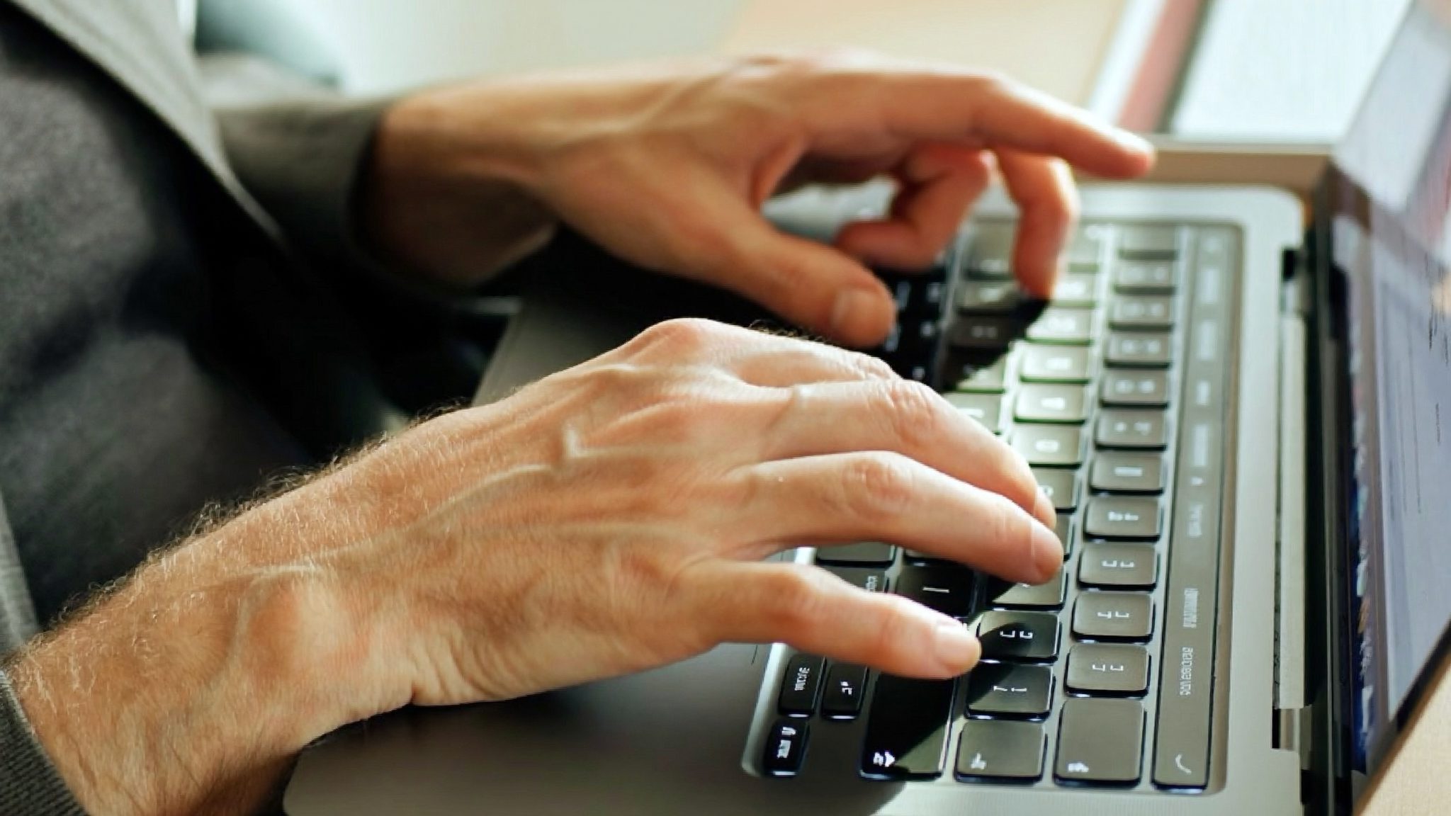 Un apprenant pose ses mains sur le clavier d'un ordinateur portable lors d'une séance d'initiation